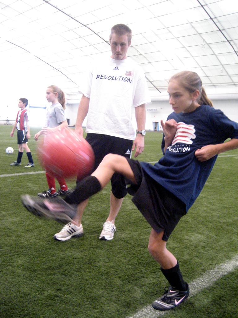 Brad Knighton watching as Liz McCarthy, 12, of Winchester does a drill